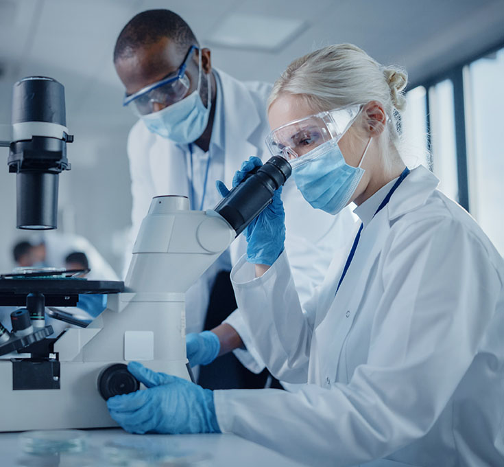Des techniciens de laboratoire étudient des échantillons biologiques à l'aide d'un télescope moderne.