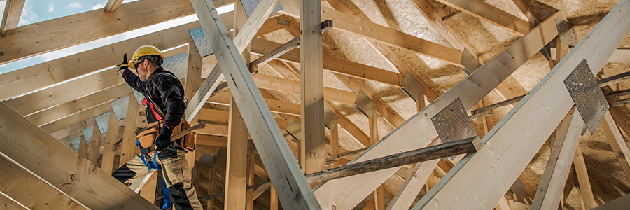 Un ouvrier dans le chevron d’une maison en construction.