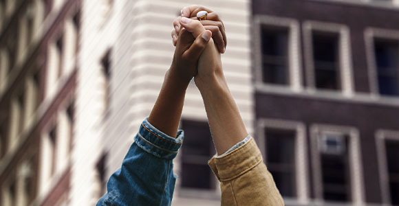 Deux mains appartenant à des personnes de races différentes sont jointes dans les airs