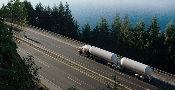 Un camion transportant de l’hydrogène sur une autoroute entourée de lacs et de collines