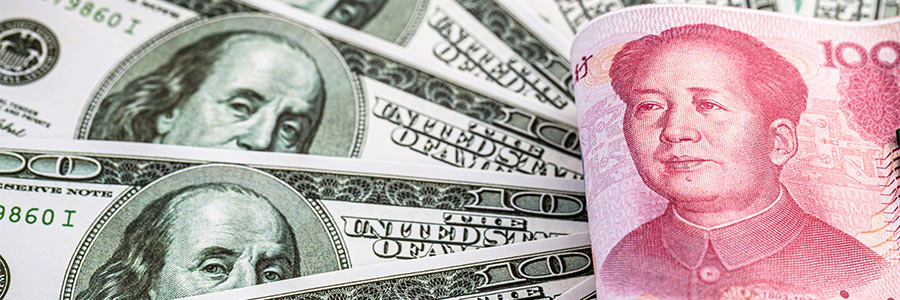 Billets en yuan pliés, posés au-dessus de plusieurs billets en dollars américains.
