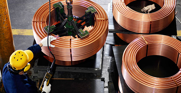 Professionnels du secteur minier manipulant du cuivre dans une usine.