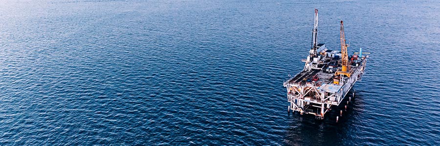 Aerial photo of an oil rig surrounded by ocean.