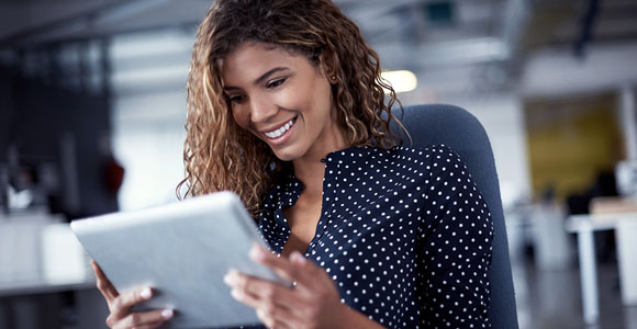 Une femme regarde l’écran de sa tablette. 