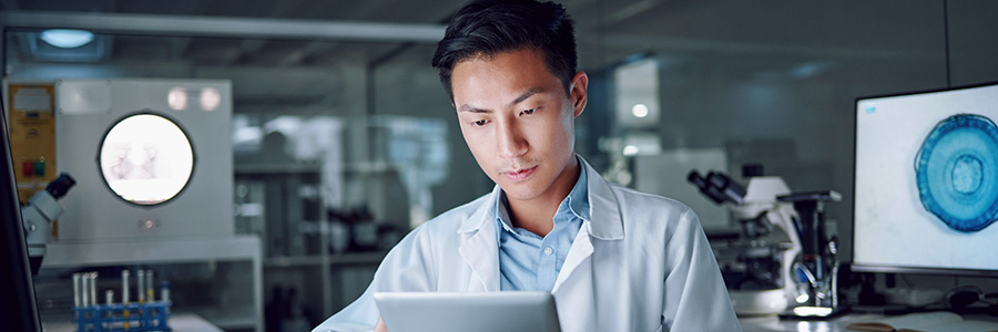 Un technicien de laboratoire regarde une tablette.