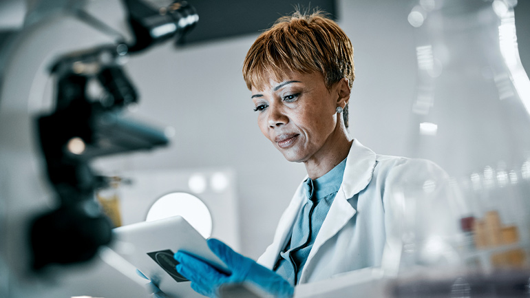 Une technicienne de laboratoire examine des renseignements sur une tablette.