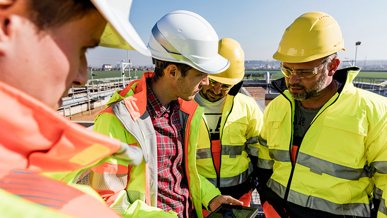 Workers in hard hats outside a biofuel plant.